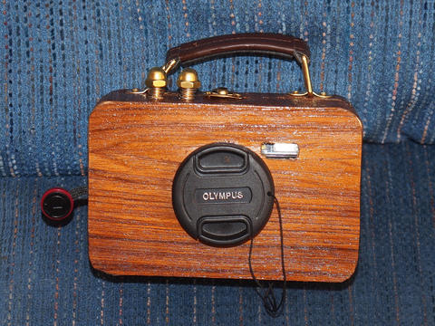 Travel camera suitcase with shutter/on buttons and attached lens cap
